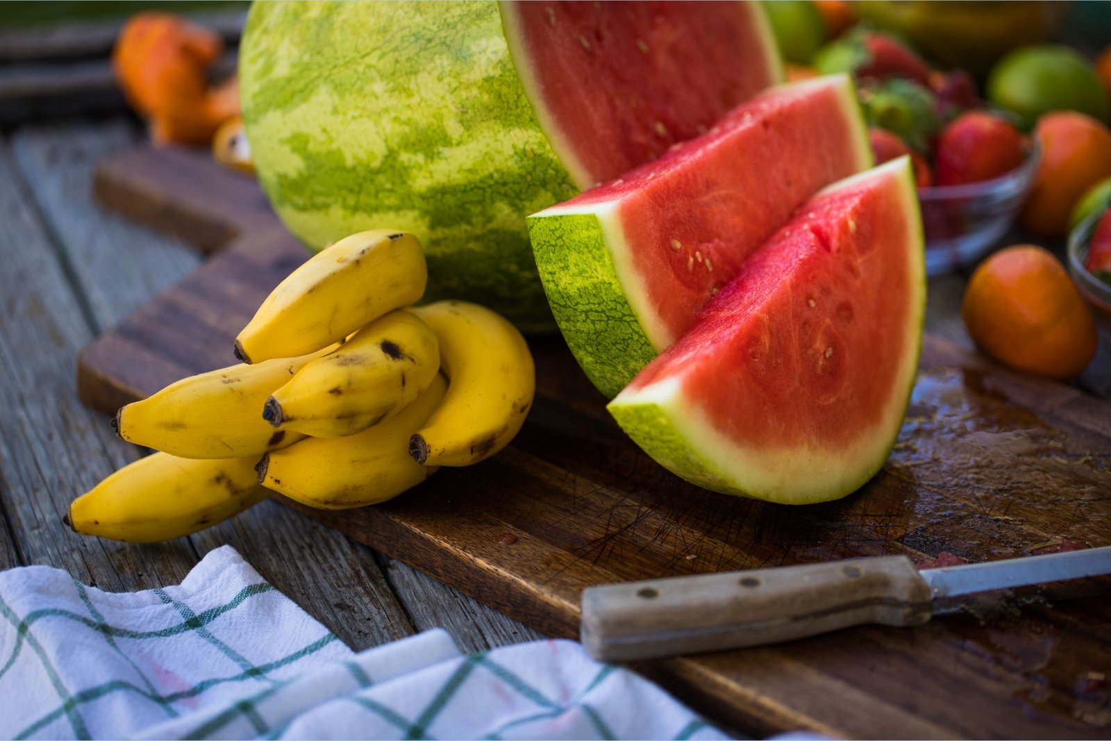 Kalíumríkir bananar liggja á skurðbretti við hliðina á L-sítrullínríkri, sneiddri vatnsmelónu